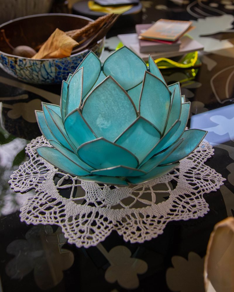 A teal lotus candle holder on a lace doily in the consulting room